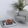 A dog is lying on a dog bed in a living room setting, next to a chair and a plant. Anteprima dell’immagine prodotto