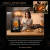 A woman is using a rotisserie grill in a kitchen, with a cooked chicken and other food items visible. Náhled obrázku produktu