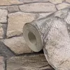 A close-up of a roll of wallpaper with a stone pattern. Produktbild-Vorschau