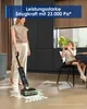 A woman is using a wet dry vacuum cleaner on a floor, while a child sits at a table in the background. Náhled obrázku produktu
