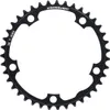 A black bicycle chainring with teeth and circular cutouts, set against a white background. Podgląd zdjęcia produktu