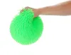 A hand is squeezing a green puffer ball. Produktbild-Vorschau