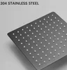 A close-up of a black square shower head with multiple small white nozzles. Náhled obrázku produktu