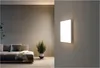 A modern living room with a sofa and a plant, illuminated by a square LED panel mounted on the wall. Produktbild-Vorschau