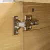 A close-up view of a cabinet hinge on a wooden surface. Voir les images du produit