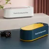 Two ultrasonic cleaning machines are shown, one white and one blue and yellow, with a smartwatch placed next to the blue one. Produktbild-Vorschau