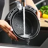 A person is rinsing the basket of an air fryer in a sink. Produktbild-Vorschau