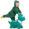 A child in a dinosaur costume is riding a green inflatable dinosaur toy. Podgląd zdjęcia produktu