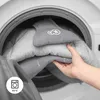 A hand is placing a gray baby product into a washing machine, with a laundry symbol indicating 30°C. Anteprima dell’immagine prodotto