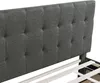 Close-up view of a gray upholstered headboard and bed frame. Náhled obrázku produktu