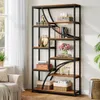 A tall, multi-shelf bookshelf filled with books and decorative items, placed next to a window with sheer curtains. Voir les images du produit