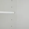 A close-up view of a white shelf attached to a light gray wall with visible screw holes. Podgląd zdjęcia produktu