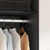 A close-up view of clothes hanging on a rail inside a wardrobe. Produktbild-Vorschau
