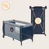 A baby crib and a folded crib are shown against a light beige background. The crib is blue with gray and orange accents. The folded crib is also blue and has a lock icon overlay. Produktbild-Vorschau