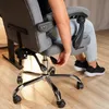 A close-up of a person adjusting a lever on a gray office chair with a chrome base. Produktbild-Vorschau