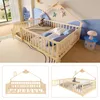 A children's bed with a house-shaped frame and safety rails, shown in a bedroom setting and in close-up views. Voir les images du produit