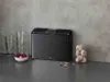 A kitchen counter scene with a cutting board set, glasses, and garlic. Anteprima dell’immagine prodotto