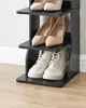 A black wooden shoe rack with multiple shelves, holding various pairs of shoes. Náhled obrázku produktu