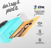 A close-up of a blue instant camera printing a photo of a person wearing sunglasses and a colorful hat. Anteprima dell’immagine prodotto
