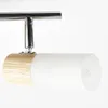 A close-up view of a modern ceiling spotlight with a wooden base and a frosted glass shade. Produktbild-Vorschau