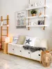 A cozy living room corner with a wooden ladder, a storage bench with cushions, and shelves on the wall. Voir les images du produit