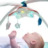 A baby is lying on its back and looking up at a baby gym with hanging toys and lights. Produktbild-Vorschau