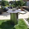 An outdoor patio with a fire pit table, seating area, and dining table. Anteprima dell’immagine prodotto