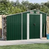 A green metal shed with double doors and a side storage area for firewood, set in a backyard with a fence and trees. Náhled obrázku produktu