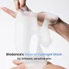 Hands holding a white hydrogel face mask against a white background. Produktbild-Vorschau