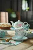 A tea set with a cake on a wooden table. Produktbild-Vorschau