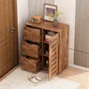 A wooden storage cabinet with drawers and a door, placed in an entryway or hallway next to a door and on a rug. Podgląd zdjęcia produktu