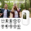 A couple hiking in a forest, with a small white camcorder prominently displayed and feature icons below. Náhled obrázku produktu