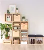 A modular wooden cube shelving unit filled with decorative items, plants, and storage boxes, next to a bench with cushions and shoes. Anteprima dell’immagine prodotto