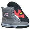 A pair of gray winter work boots with a red and black sole is shown against a white background. The sole is partially visible behind the boot. Produktbild-Vorschau