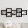 A black wall shelf unit mounted on a white wall above a sofa. Náhľad obrázku produktu