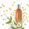 A bottle of Clinique Aromatics Elixir perfume surrounded by chamomile flowers and jasmine. Produktbild-Vorschau
