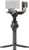 A camera gimbal stabilizer with a camera attached, shown from the front with its tripod legs extended. Náhled obrázku produktu
