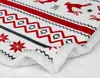 A close-up view of a white blanket with a red and gray Nordic-inspired pattern, featuring reindeer and snowflake motifs. The fluffy white sherpa lining is visible along the edge. Produktbild-Vorschau