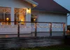 A house with a deck decorated with icicle lights at dusk. Produktbild-Vorschau