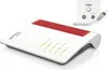 A white FRITZ!Box cable router with red accents is shown on a white background, along with a wall socket for cable TV and radio. Produktbild-Vorschau