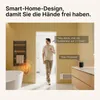 A man is in a bathroom, holding a device and speaking to a smart speaker. A towel rack is visible on the wall. Produktbild-Vorschau