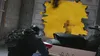 Two people in a video game, one in the foreground aiming a weapon, and another in the background obscured by yellow smoke. Produktbild-Vorschau