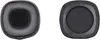Two black ear pads for headphones are shown against a white background. One is shown from the front, and the other from the back. Produktbild-Vorschau