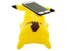 A yellow Pikachu-shaped phone stand with a smartphone placed on top. Produktbild-Vorschau