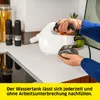 A person is holding a white handheld steam cleaner over a kitchen counter. Voir les images du produit