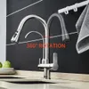 A kitchen faucet with a pull-out spray head is shown in a modern kitchen setting, with a towel hanging in the background. Náhľad obrázku produktu