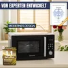A black and silver microwave oven is shown on a countertop, with promotional text and a certificate in the background. Produktbild-Vorschau