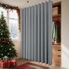 A Christmas tree and gifts are in the foreground, with a gray room divider curtain and a closet in the background. Produktbild-Vorschau