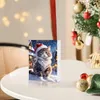 A Christmas advent calendar with a cat illustration sits on a table next to a decorated Christmas tree. Produktbild-Vorschau