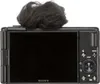 The back of a black Sony digital camera with a furry microphone attachment on top. Produktbild-Vorschau